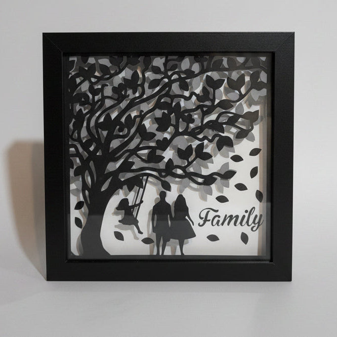 Framed artwork with a family tree design on a white wall.