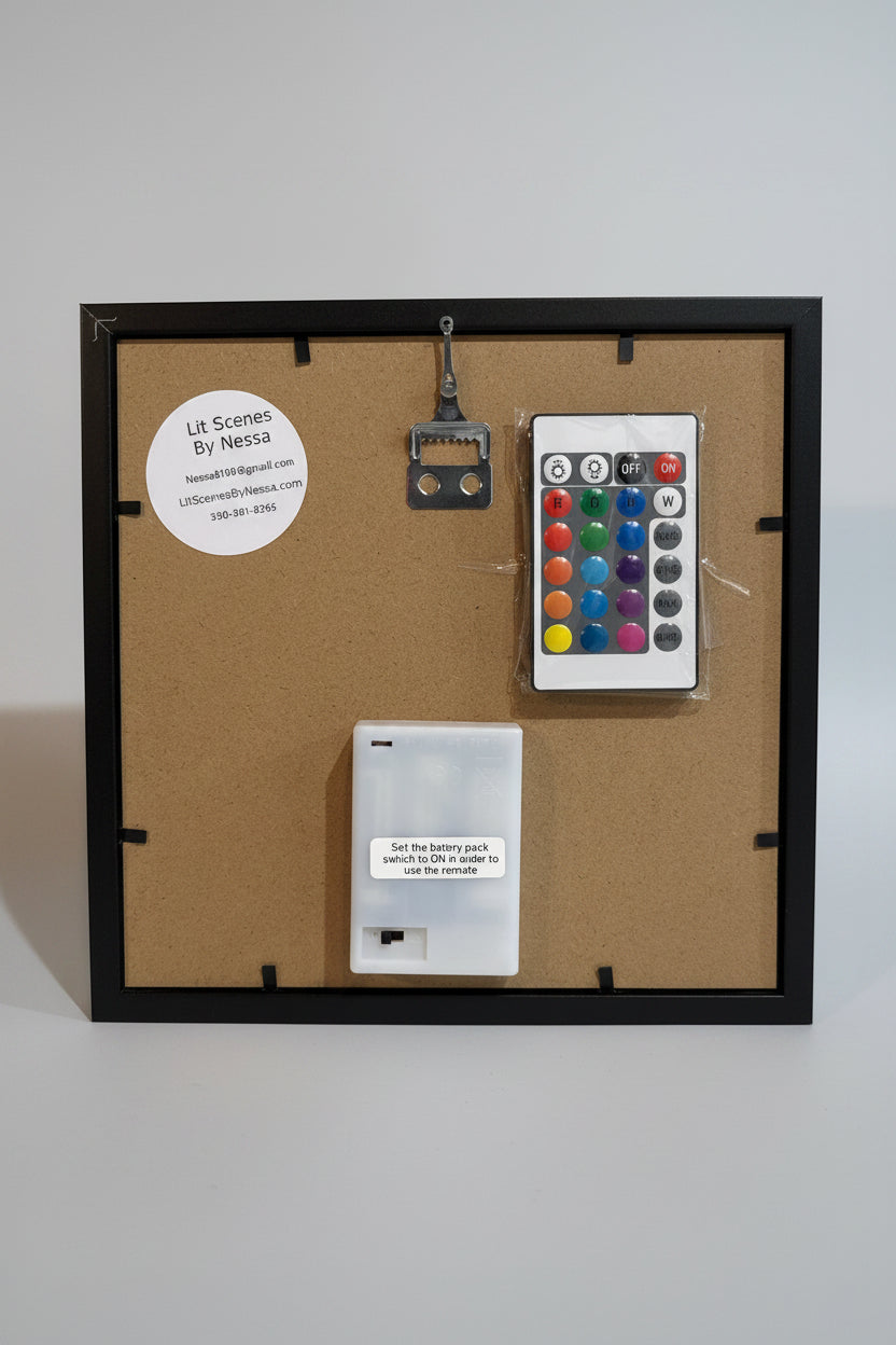 Back view of a framed artwork with electronic components on a white wall.