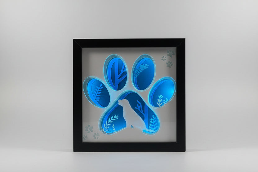 Framed artwork of a blue paw print on a white background