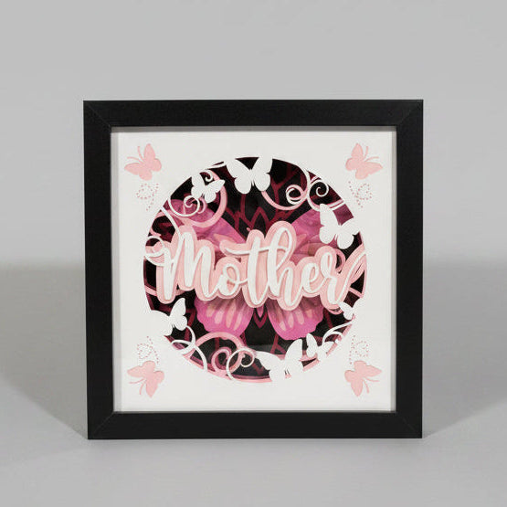 Framed decorative artwork with 'Mother' and floral designs on a wall.