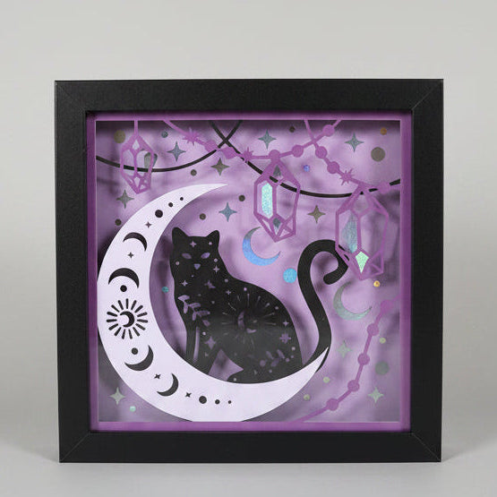 Framed artwork with a black cat silhouette on a purple background