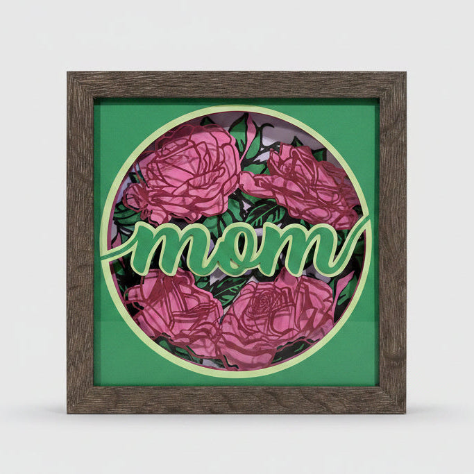 Decorative wall art with 'mom' and floral design in a wooden frame.
