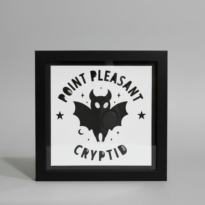 Framed artwork with 'Point Pleasant Crypto' design on a white wall.