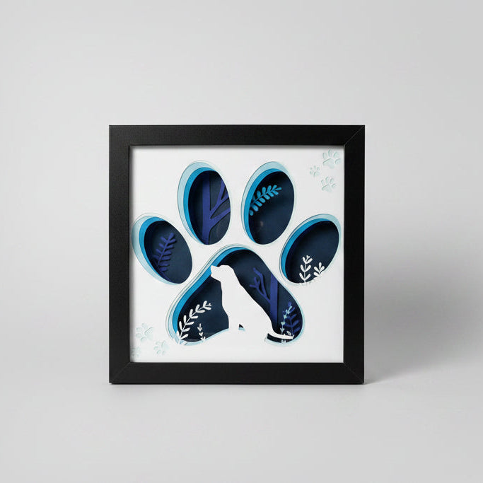 Framed artwork of blue and black paw designs on a white background